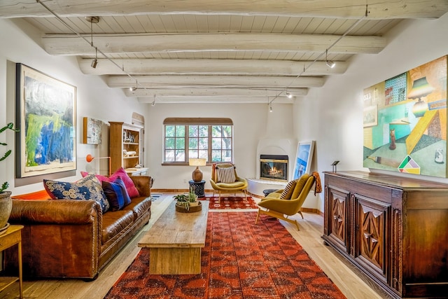 living room featuring track lighting, wood ceiling, beam ceiling, a fireplace, and wood-type flooring