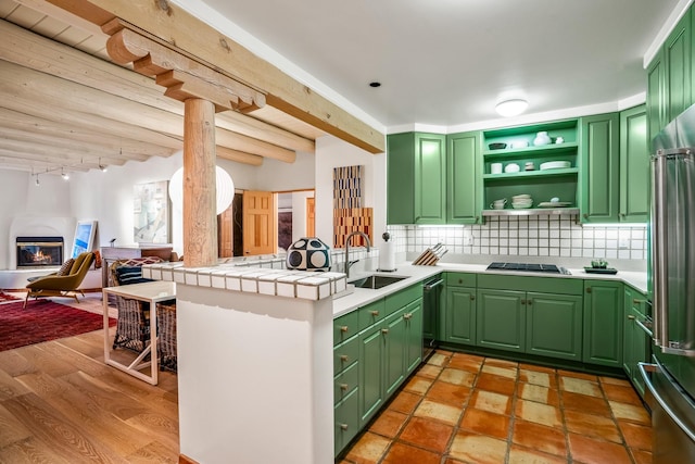 kitchen with sink, green cabinets, tile countertops, and kitchen peninsula