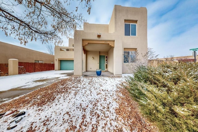 pueblo-style home featuring a garage