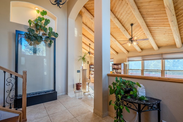 tiled foyer entrance with a ceiling fan, wooden ceiling, stairway, and lofted ceiling with beams