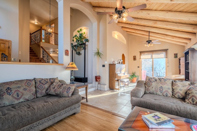 living room with wood ceiling, stairway, beam ceiling, and ceiling fan with notable chandelier