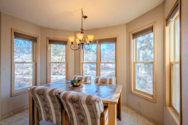 dining room with an inviting chandelier, a wealth of natural light, and light tile patterned flooring