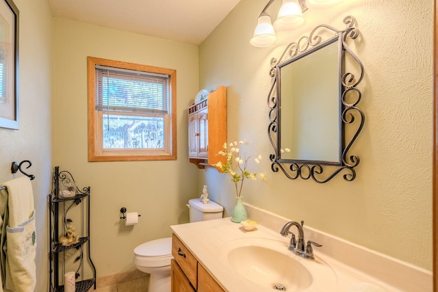 half bathroom featuring toilet, tile patterned floors, and vanity