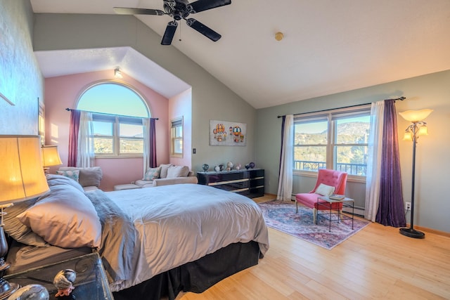 bedroom with ceiling fan, vaulted ceiling, and wood finished floors