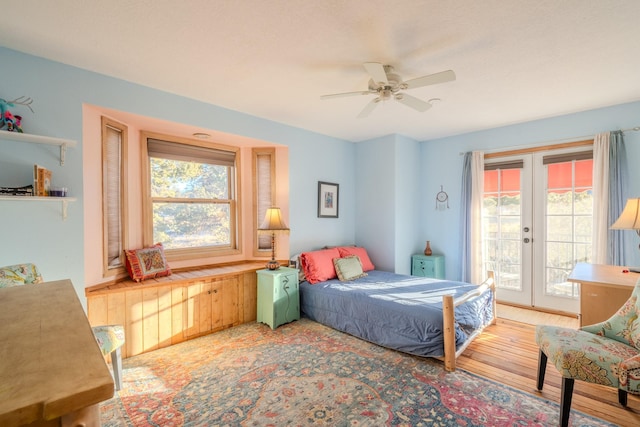 bedroom with access to outside, french doors, multiple windows, and wood finished floors