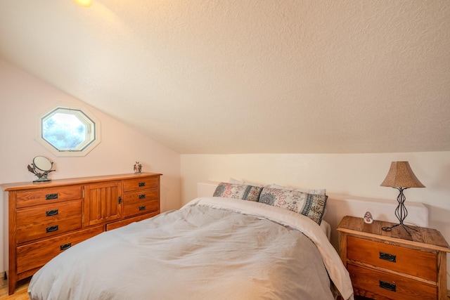 bedroom with lofted ceiling and a textured ceiling