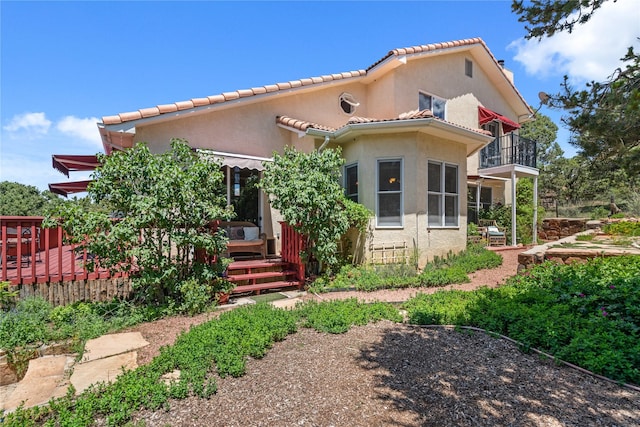 mediterranean / spanish-style house with a tiled roof, a balcony, and stucco siding