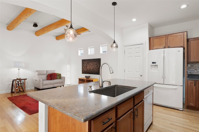 kitchen featuring sink, beamed ceiling, white appliances, an island with sink, and hanging light fixtures