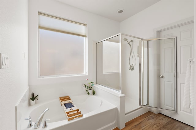 bathroom featuring hardwood / wood-style flooring, a healthy amount of sunlight, and independent shower and bath