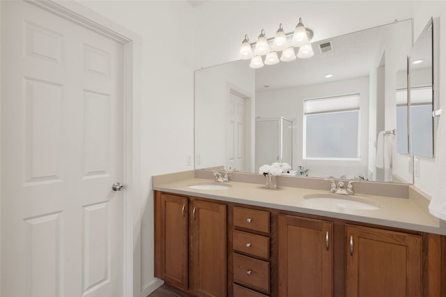 bathroom with a shower with door and vanity