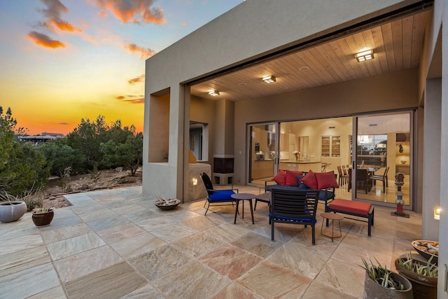 patio terrace at dusk featuring an outdoor living space