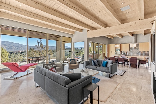 living room featuring a mountain view, light tile patterned floors, wooden ceiling, and beamed ceiling