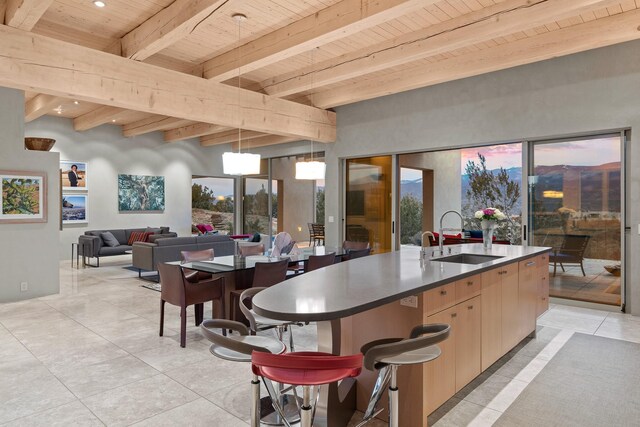 kitchen with pendant lighting, sink, wood ceiling, beam ceiling, and light brown cabinets