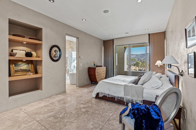 bedroom featuring connected bathroom, a mountain view, and light tile patterned floors