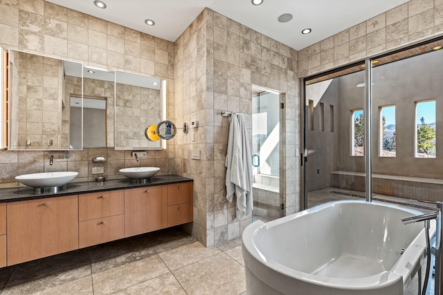 bathroom featuring vanity, shower with separate bathtub, tile walls, and tile patterned floors