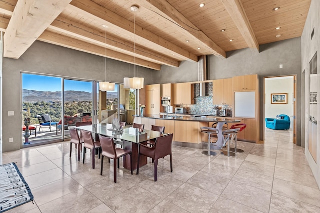 tiled dining area featuring a high ceiling, a mountain view, wooden ceiling, and beam ceiling