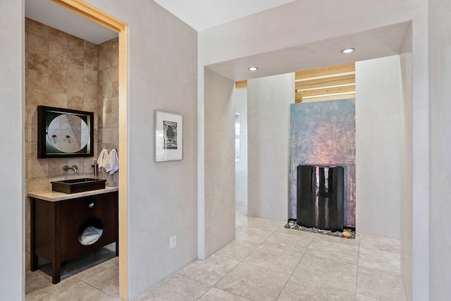 hallway featuring sink and light tile patterned floors