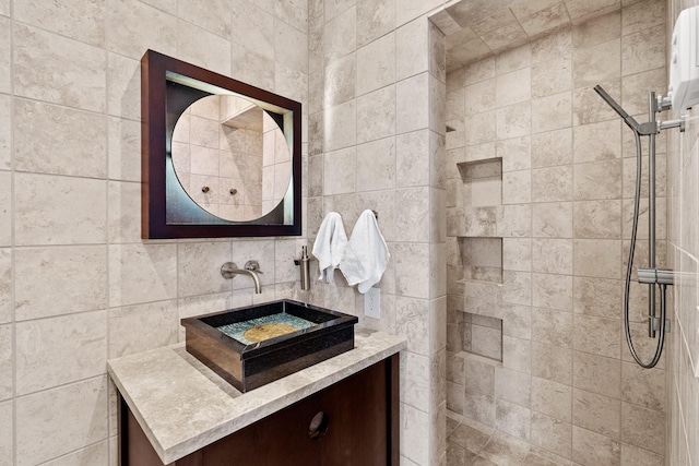 bathroom with tiled shower, vanity, decorative backsplash, and tile walls