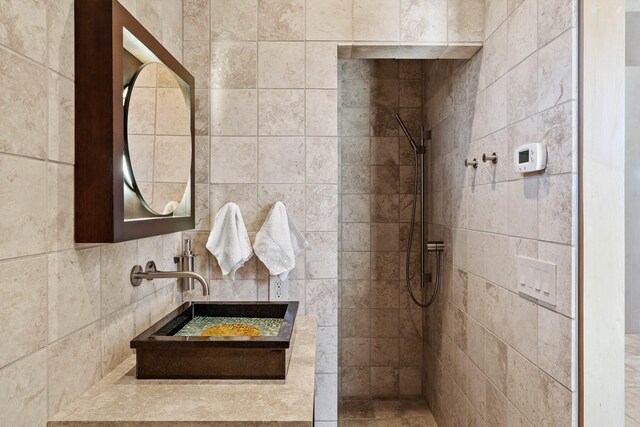 bathroom with a tile shower and vanity