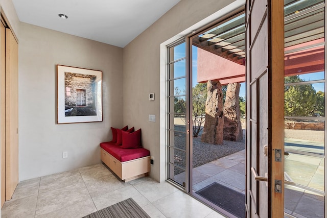 doorway with light tile patterned flooring and a wealth of natural light