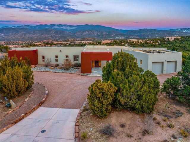 adobe home with a garage and a mountain view