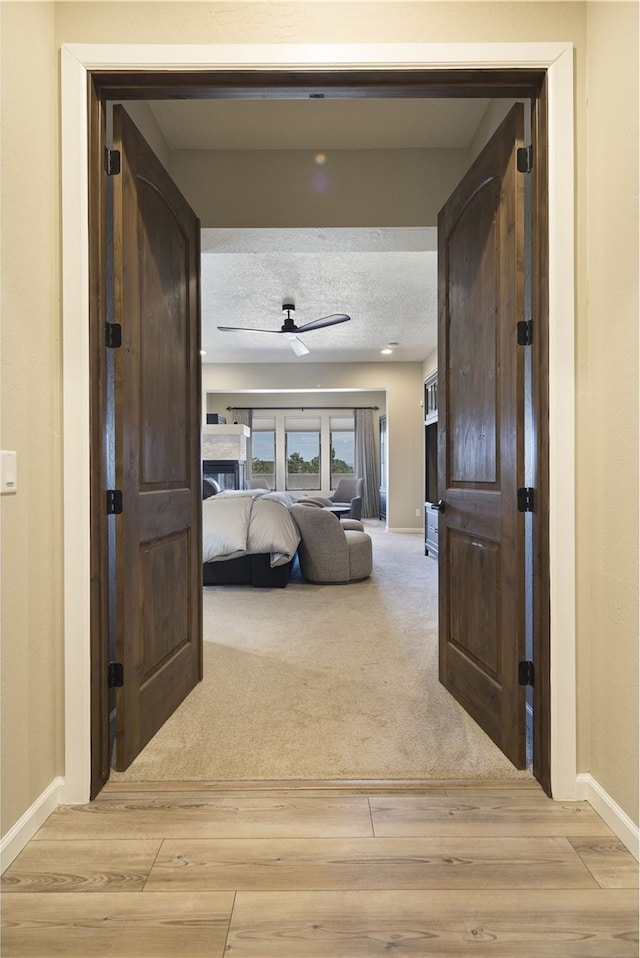 hallway with a textured ceiling and hardwood / wood-style floors