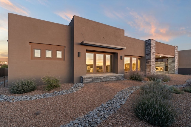 back house at dusk with a patio area