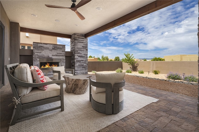 view of patio / terrace featuring an outdoor living space with a fireplace and ceiling fan