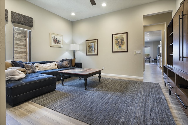 living room featuring ceiling fan and light hardwood / wood-style floors