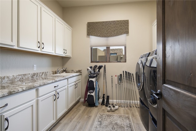 laundry room with sink, cabinets, separate washer and dryer, and light wood-type flooring