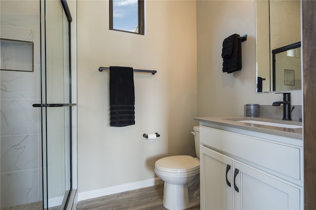 bathroom featuring hardwood / wood-style floors, toilet, an enclosed shower, and vanity