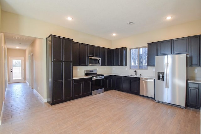 kitchen featuring appliances with stainless steel finishes, light hardwood / wood-style floors, and sink