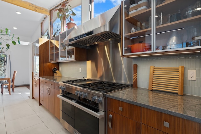 kitchen featuring tasteful backsplash, double oven range, range hood, and dark stone counters