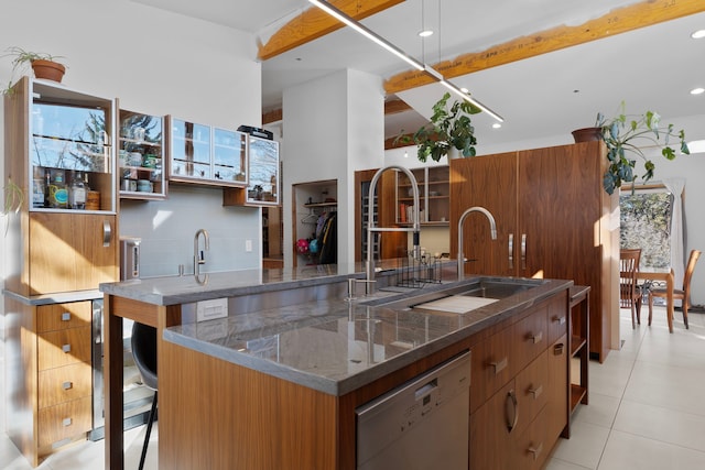 kitchen with light tile patterned flooring, dishwasher, sink, a breakfast bar area, and decorative backsplash