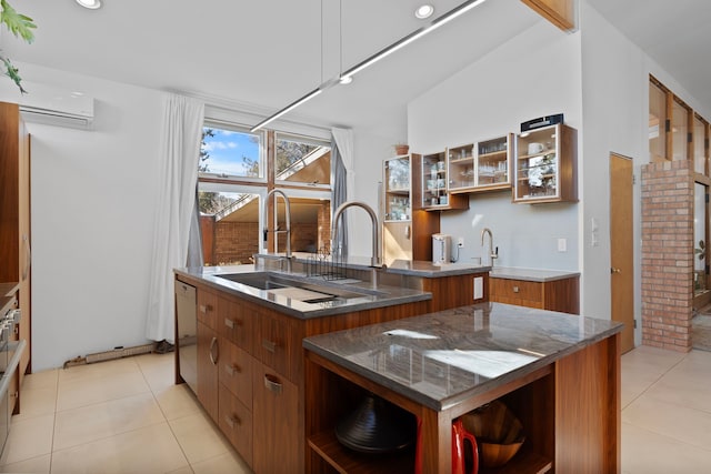 kitchen featuring an AC wall unit, sink, a kitchen island with sink, light tile patterned floors, and white dishwasher