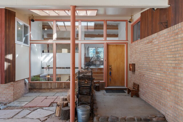 kitchen featuring decorative light fixtures, an AC wall unit, light tile patterned flooring, a kitchen island with sink, and beam ceiling