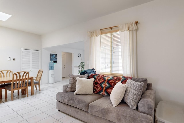 living room with a skylight and light tile patterned floors