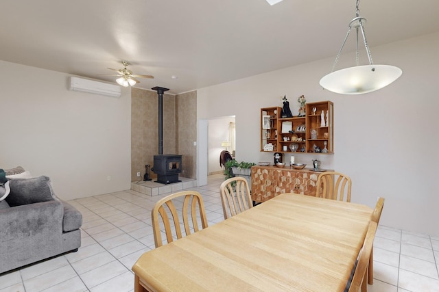 tiled dining space featuring ceiling fan, a wood stove, and a wall mounted AC