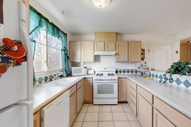 kitchen with white appliances, tasteful backsplash, light brown cabinetry, sink, and light tile patterned floors