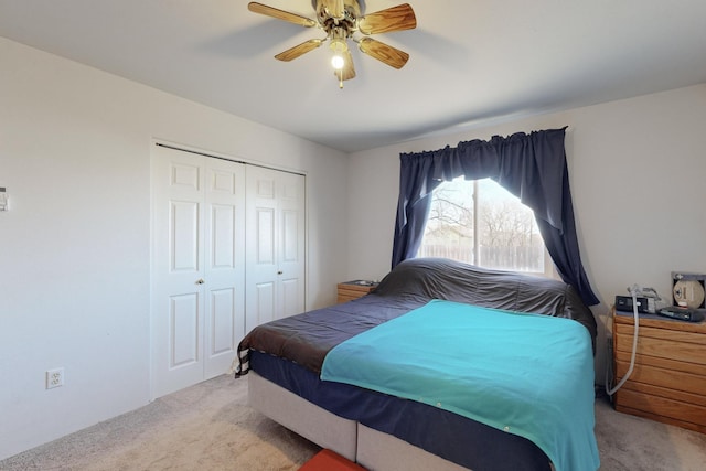 bedroom with light carpet, ceiling fan, and a closet