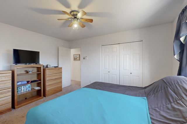 carpeted bedroom featuring ceiling fan and a closet