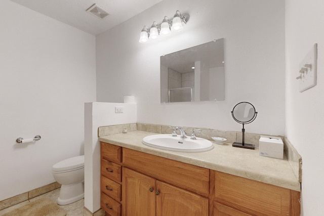 bathroom with a shower with shower door, tile patterned floors, vanity, and toilet