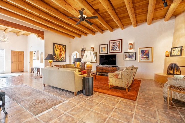 living room with ceiling fan, tile patterned flooring, beam ceiling, a large fireplace, and wood ceiling