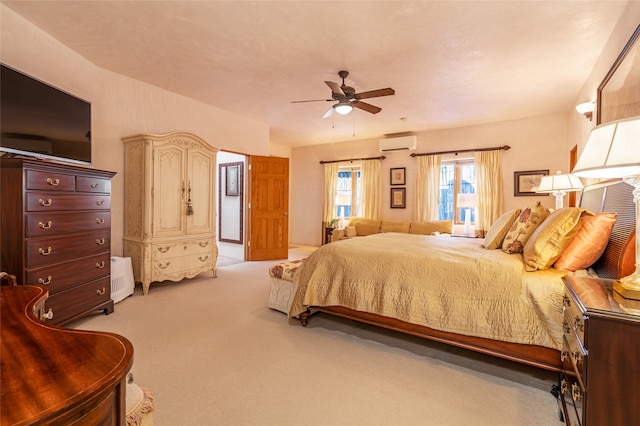 bedroom with ceiling fan, light colored carpet, and an AC wall unit