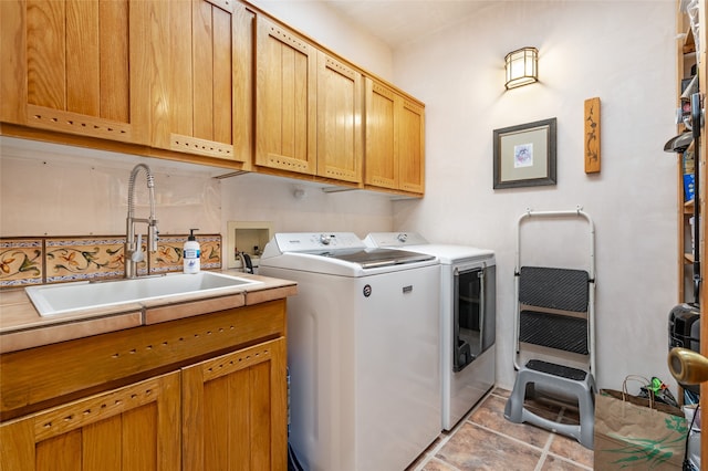 laundry area featuring washer and dryer, sink, and cabinets