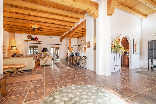 living room featuring wooden ceiling, beam ceiling, a towering ceiling, and ceiling fan