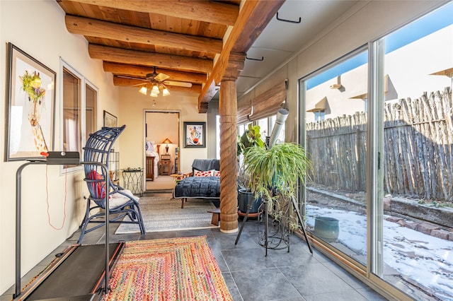 sunroom / solarium with ceiling fan, wood ceiling, and beam ceiling