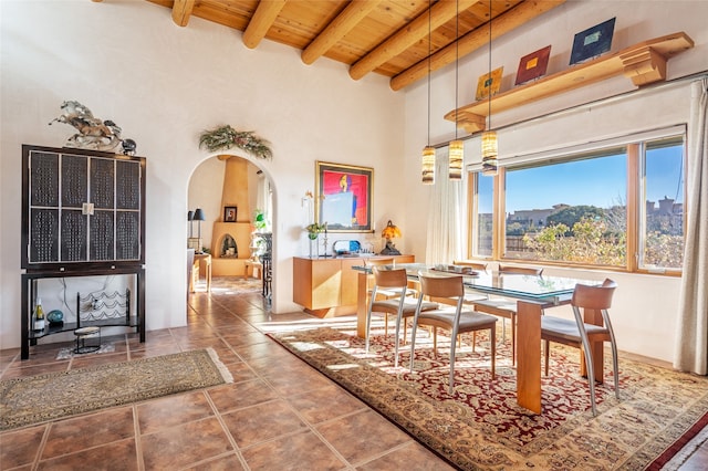 tiled dining space with beam ceiling, a high ceiling, a mountain view, and wooden ceiling