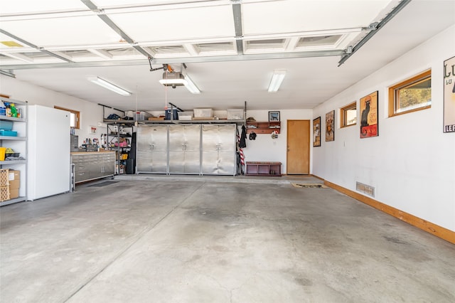 garage with a garage door opener, white fridge, and a workshop area