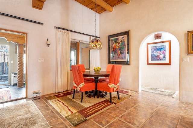 dining room featuring a high ceiling, beamed ceiling, and wood ceiling